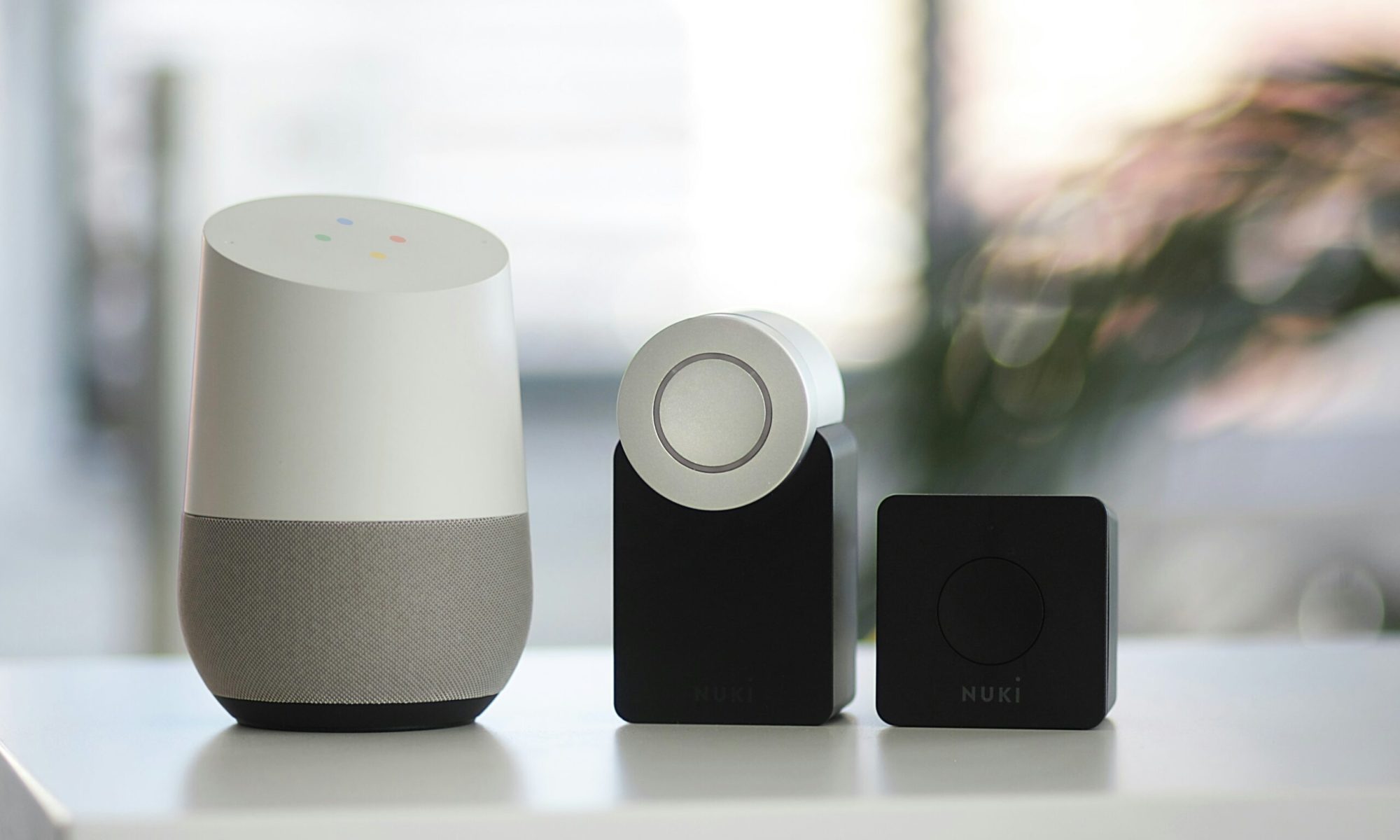 white and gray Google smart speaker and wo black speakers